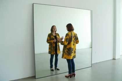Femme face à son reflet dans un miroir, explorant la différence entre identité personnelle et expression vestimentaire